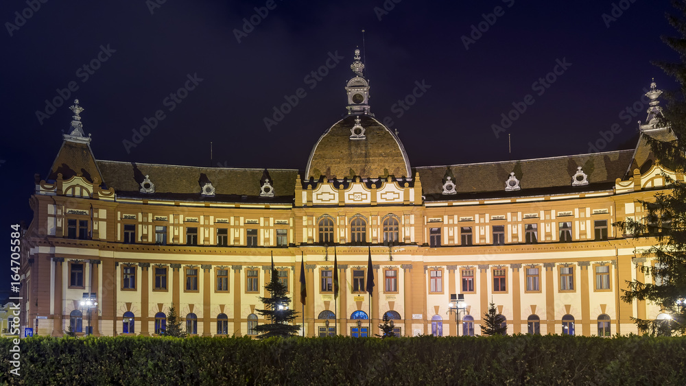 Beautiful night view of the facade of the famous Prefectura Municipiului Brasov, prefecture palace in the historic center of Brasov, Romania