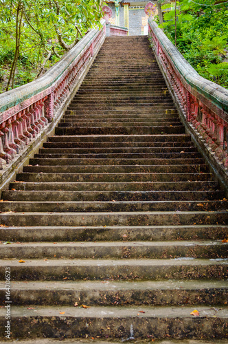 Stairway going up to the buddhist temple in jungle forest
