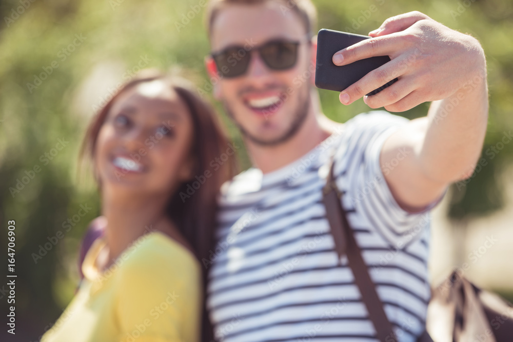 selective focus of young happy multiethnic couple taking selfie on smartphone selective focus of young happy multiethnic couple taking selfie on smartphone