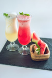 Fresh smoothie in glass with sliced pieces of watermelon and melon with mint on white isolated background. Summer drinks