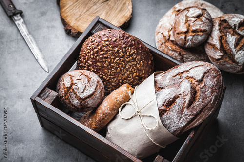A basket full of delicious fresh bread on wooden background