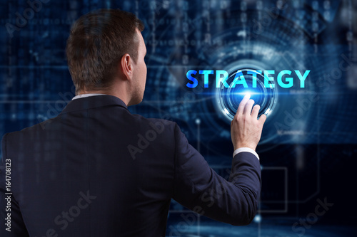 Business, Technology, Internet and network concept. Young businessman working on a virtual screen of the future and sees the inscription: Strategy