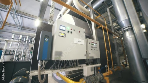 Interior industrial gas boiler with a lot of piping, pumps and valves. Modern boiler room equipment for heating system. Pipelines, water pump, valves. Engine room. Technical equipment.