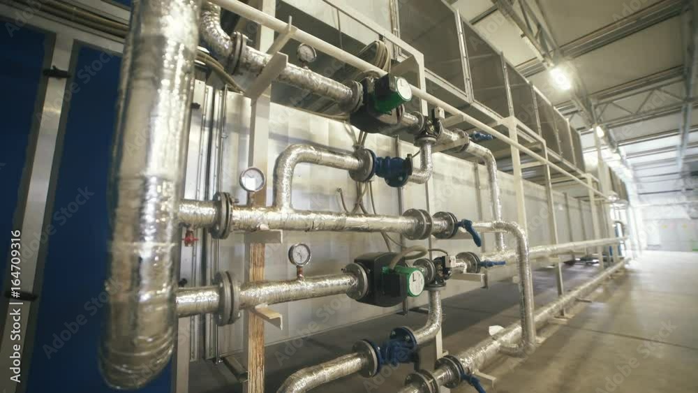 Interior industrial gas boiler with a lot of piping, pumps and valves. Modern boiler room equipment for heating system. Pipelines, water pump, valves. Engine room. Technical equipment. Interior industrial gas boiler with a lot of piping, pumps and valves. Modern boiler room equipment for heating system. Pipelines, water pump, valves. Engine room. Technical equipment.