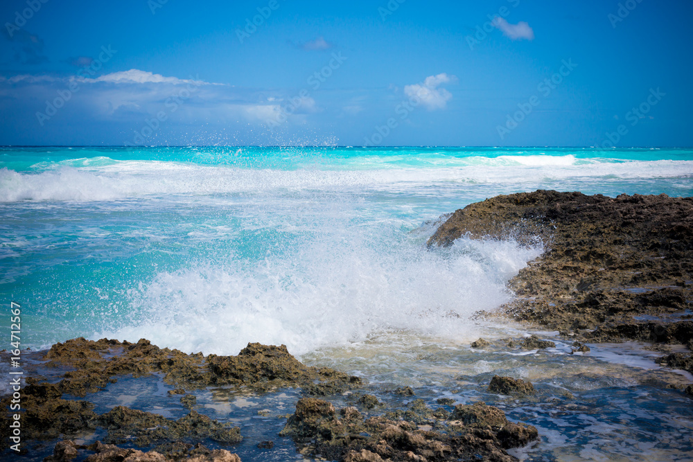 Waves crashing on rocky shore during the day on a bahmian island