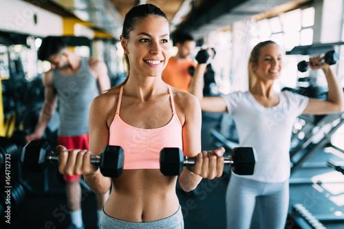 Young attractive woman with friends doing exercises in gym © NDABCREATIVITY