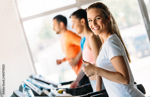 Group of friends exercising on treadmill machine