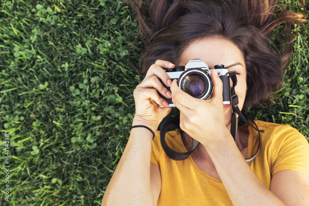 Smiling young woman using a camera to take photo. Smiling young woman using a camera to take photo.