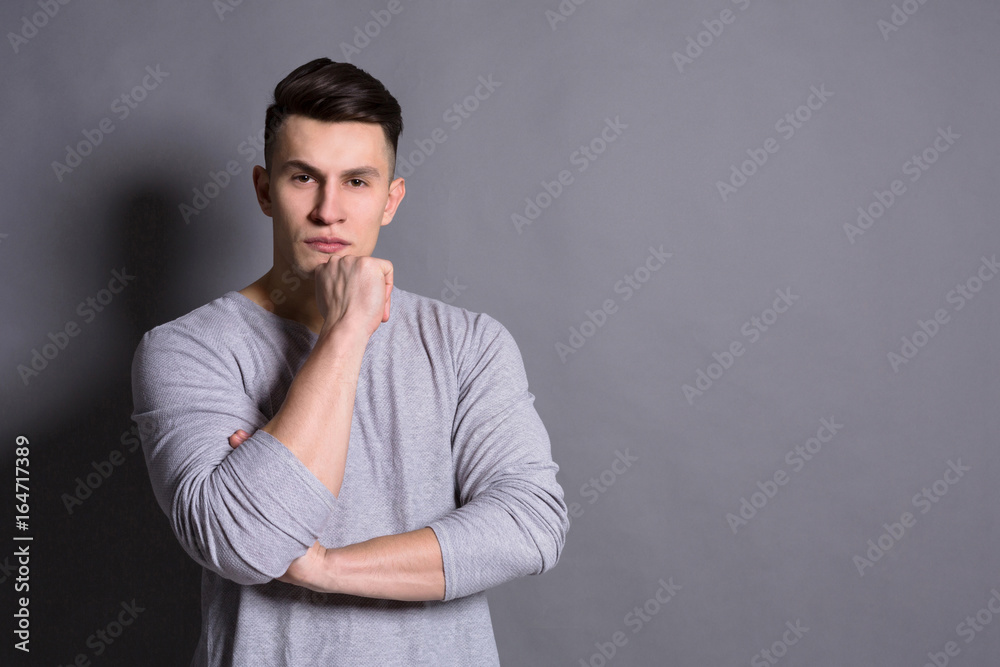 Pensive young man portrait at studio background. Pensive young man portrait at studio background.