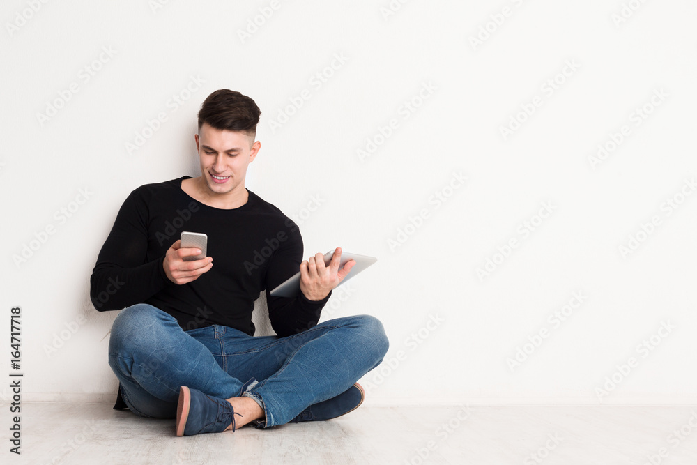 Male student study online, sit with laptop and using mobile phone Male student study online, sit with laptop and using mobile phone