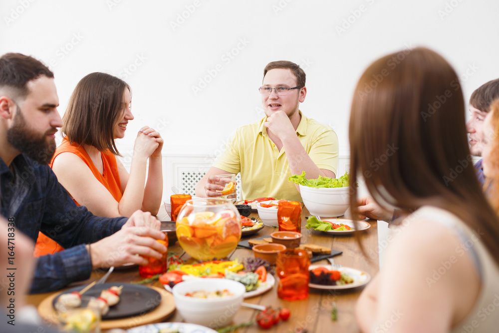 Group of happy people at festive table dinner party