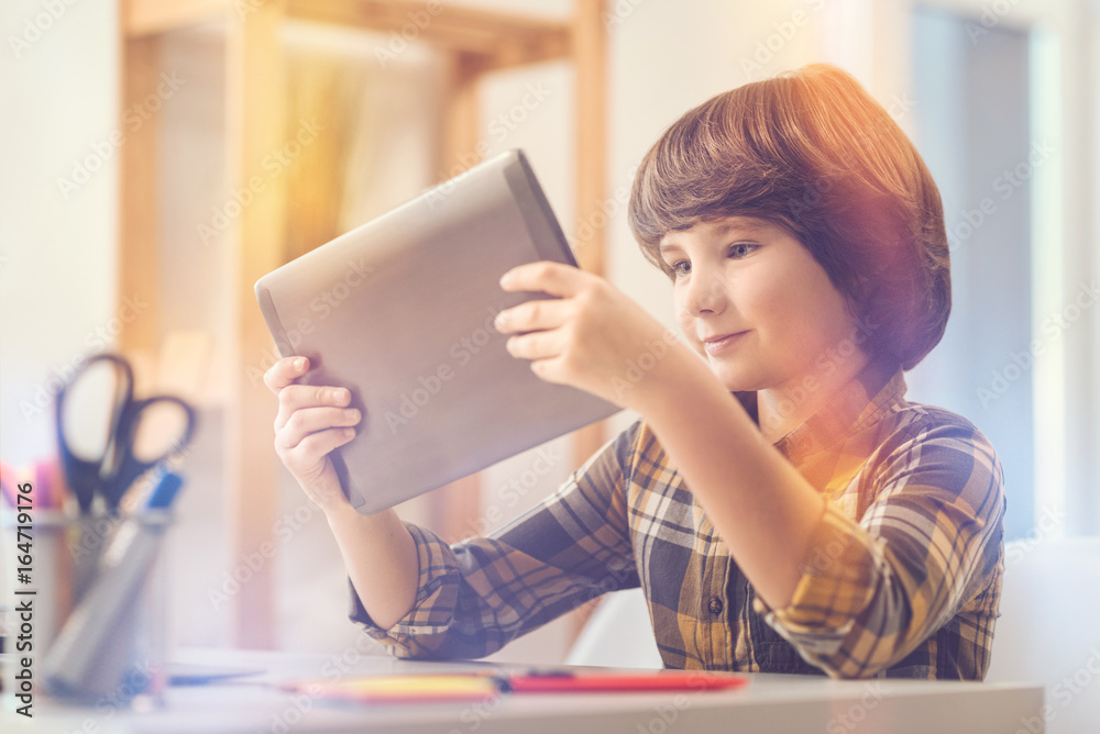 Positive joyful boy holding a tablet Positive joyful boy holding a tablet