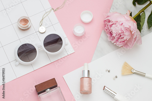 Fotografie Beauty flat lay with cosmetic bottles, phone and flower. Top view