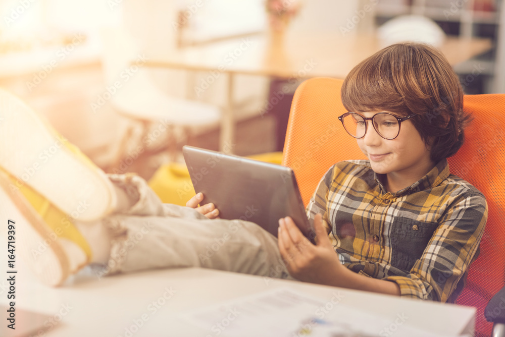 Happy delighted kid using a tablet Happy delighted kid using a tablet