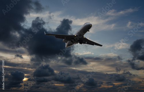 Airplane flying in sky with storm clouds