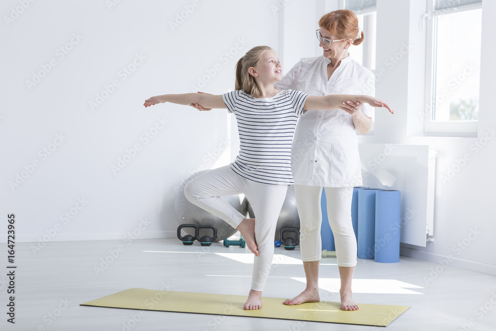 Child exercising with female physiotherapist