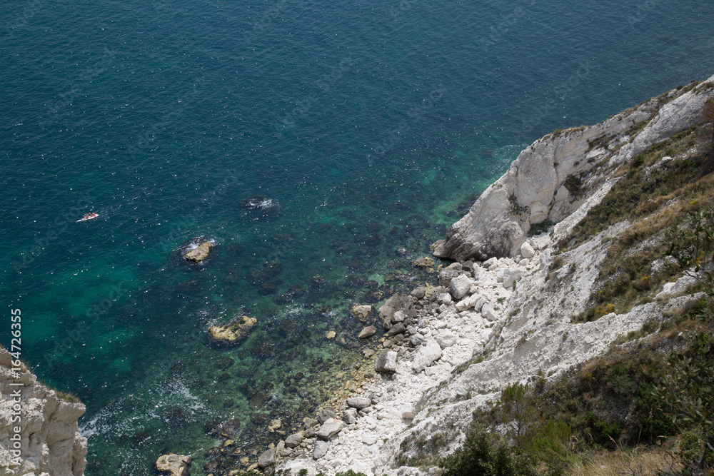 Kayaker on the cliff coast at Monte Conero, Italy