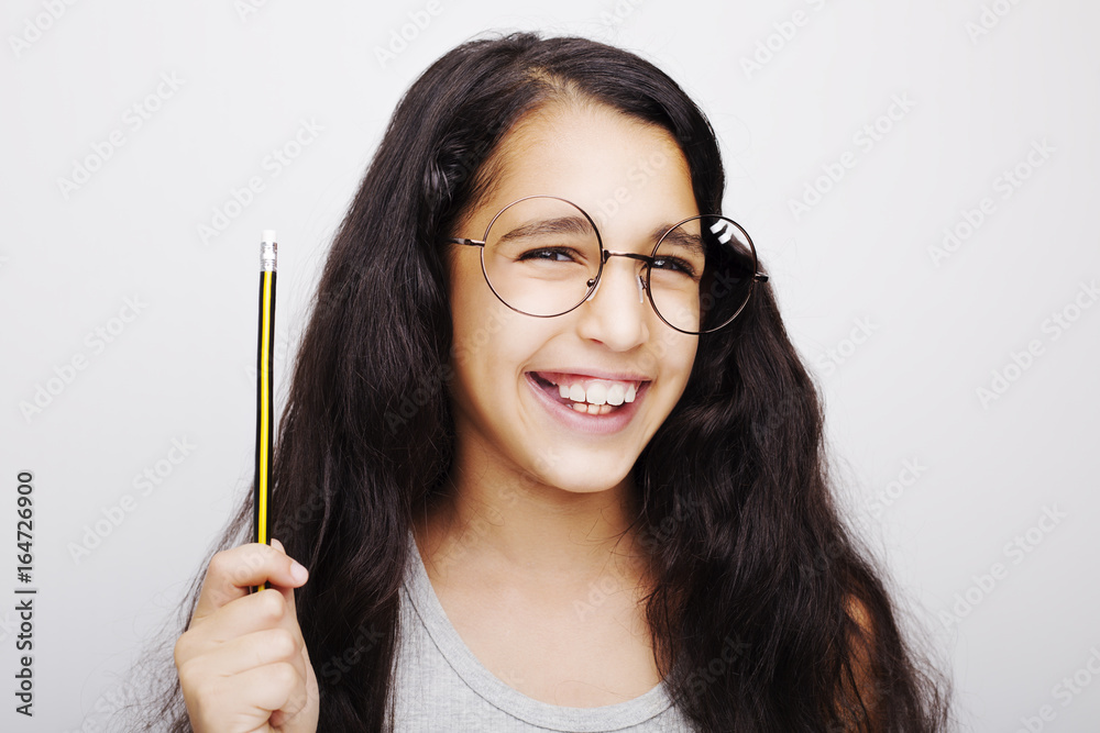 A beautiful African kid girl in glasses holding pencil in hand