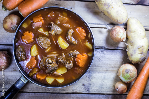 Meat stew with vegetable on rustic wooden background