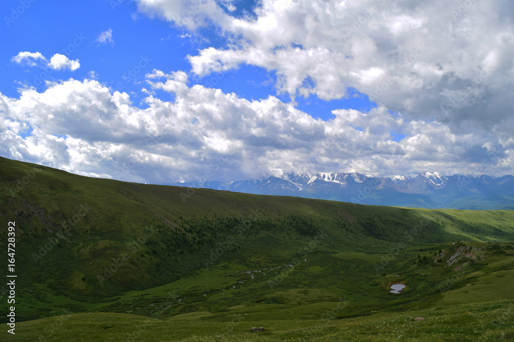 Green valley of Altai mountains and white peaks of North-Chuyski ridge. Altay Region, Siberia, Russia.