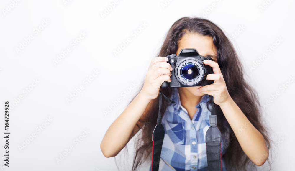 Cute brunette little girl holding an photo camera, isolated on white background Cute brunette little girl holding an photo camera, isolated on white background