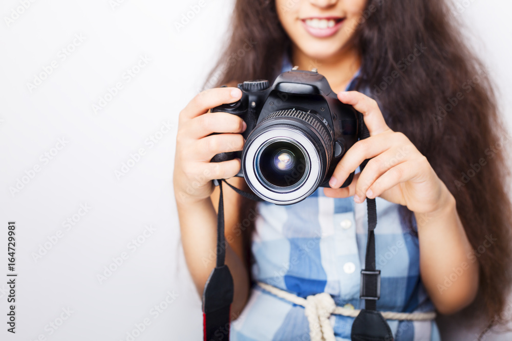 Cute brunette little girl holding an photo camera, isolated on white background Cute brunette little girl holding an photo camera, isolated on white background