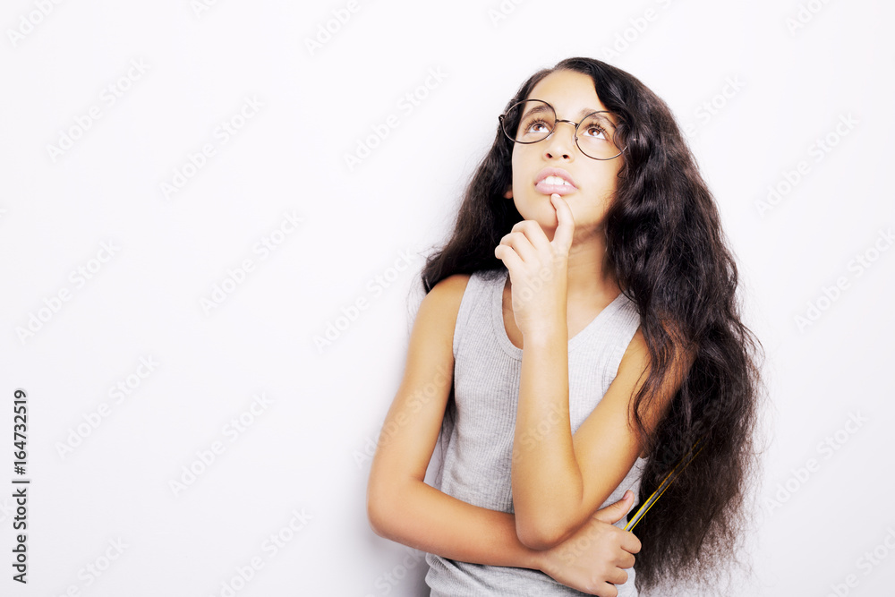 A beautiful African kid girl in glasses holding pencil in hand