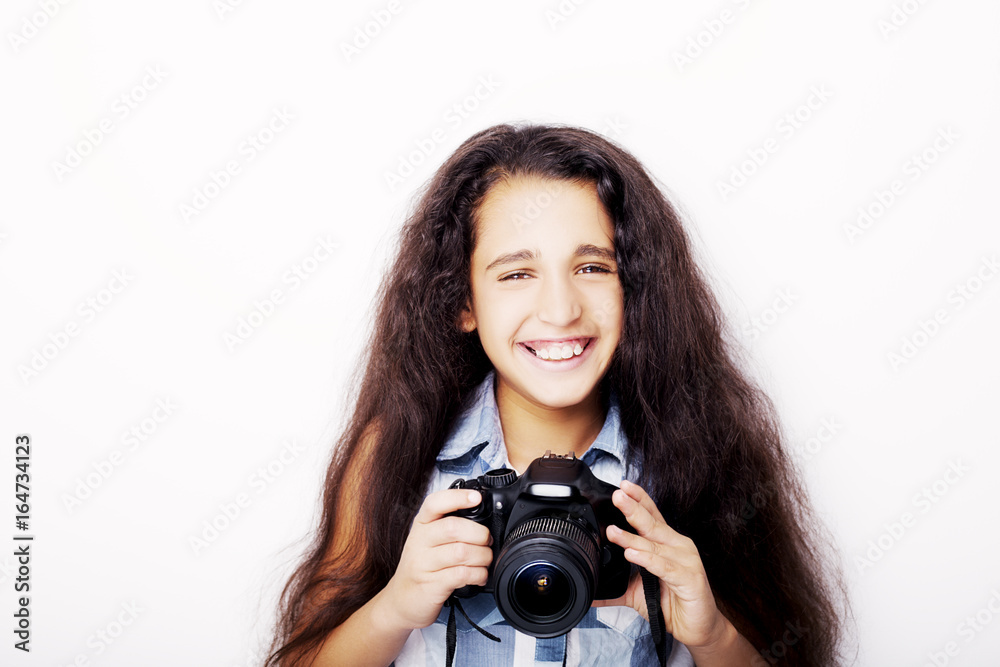 Cute brunette little girl holding an photo camera, isolated on white background Cute brunette little girl holding an photo camera, isolated on white background