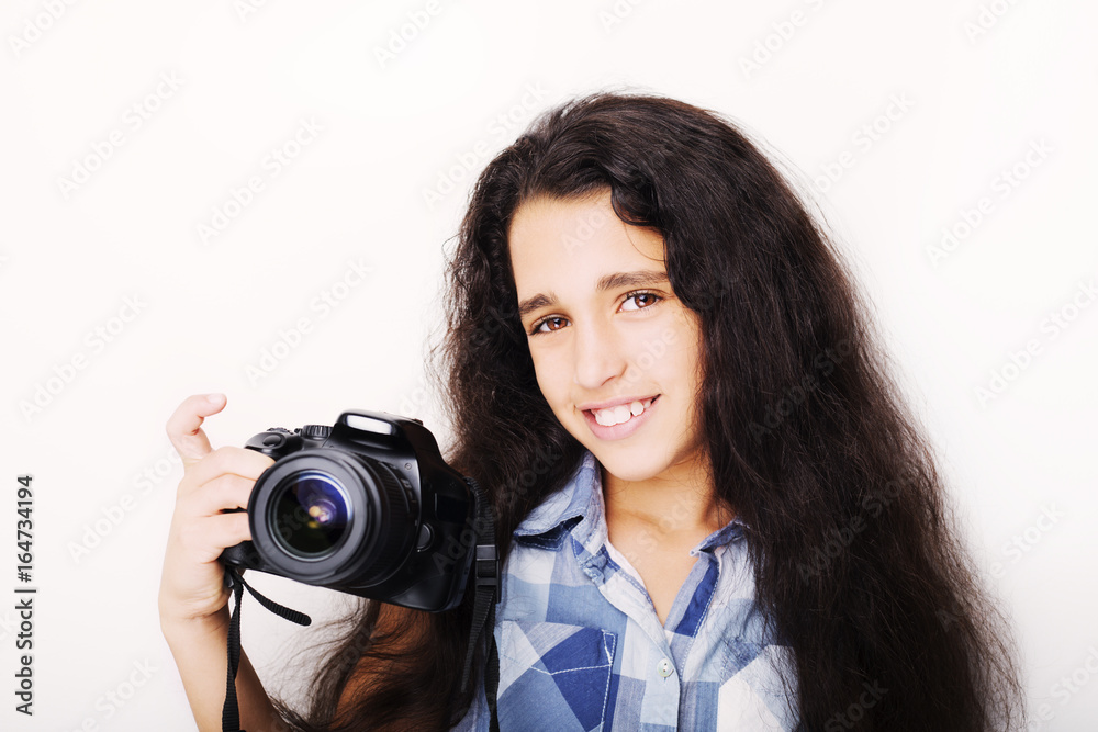 Cute brunette little girl holding an photo camera, isolated on white background Cute brunette little girl holding an photo camera, isolated on white background