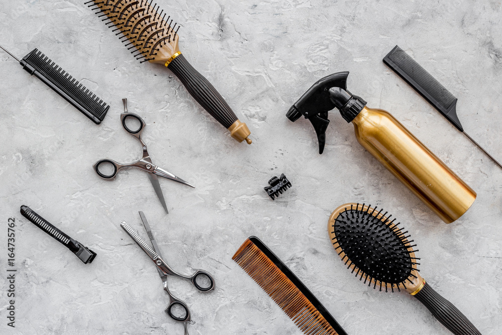 Pattern of combs and hairdresser tools on grey table background top view Pattern of combs and hairdresser tools on grey table background top view