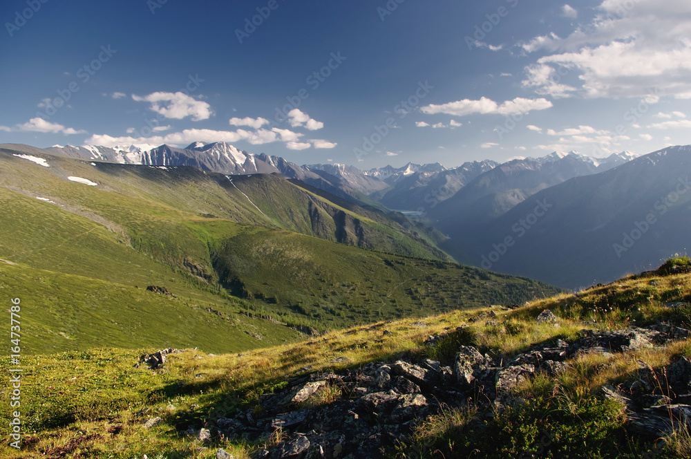 Mountain ranges valley on the background of glaciers and snow peaks view from above top height with rocks and green alpine meadow in the foreground  Altai Mountains Siberia, Russia