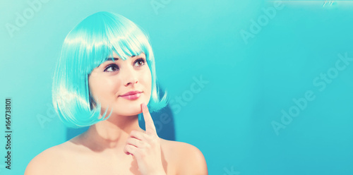 Beautiful woman in a bright blue wig on a blue background