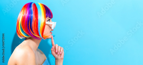 Beautiful woman in a colorful wig on a blue background