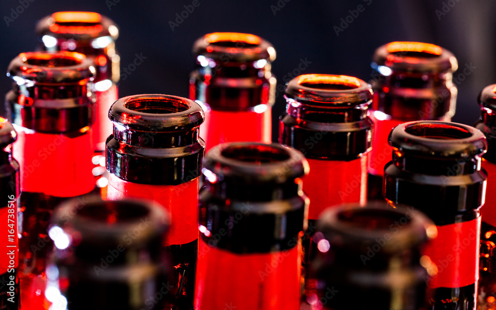 Closeup view of beer bottles from top with warm light