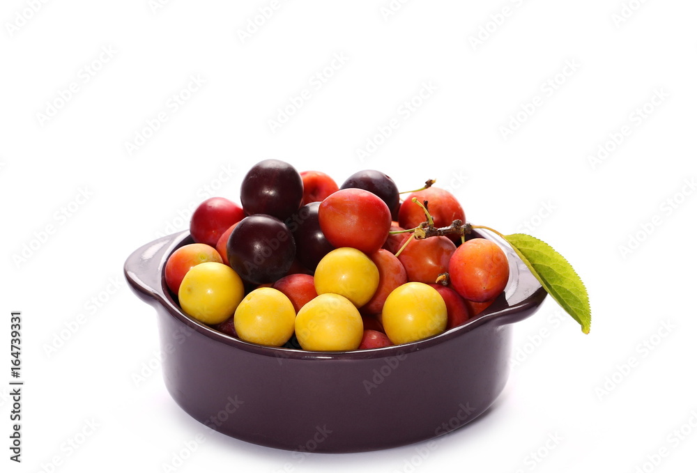 Wild plums with leaves and twigs, ringlov, in porcelain bowl isolated on white background Wild plums with leaves and twigs, ringlov, in porcelain bowl isolated on white background