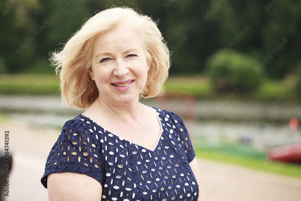 Happy elderly woman on the background of summer park Happy elderly woman on the background of summer park