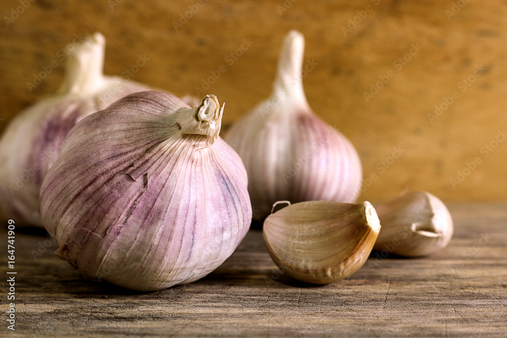 Obraz premium Garlic clove and garlic bulb on wooden background