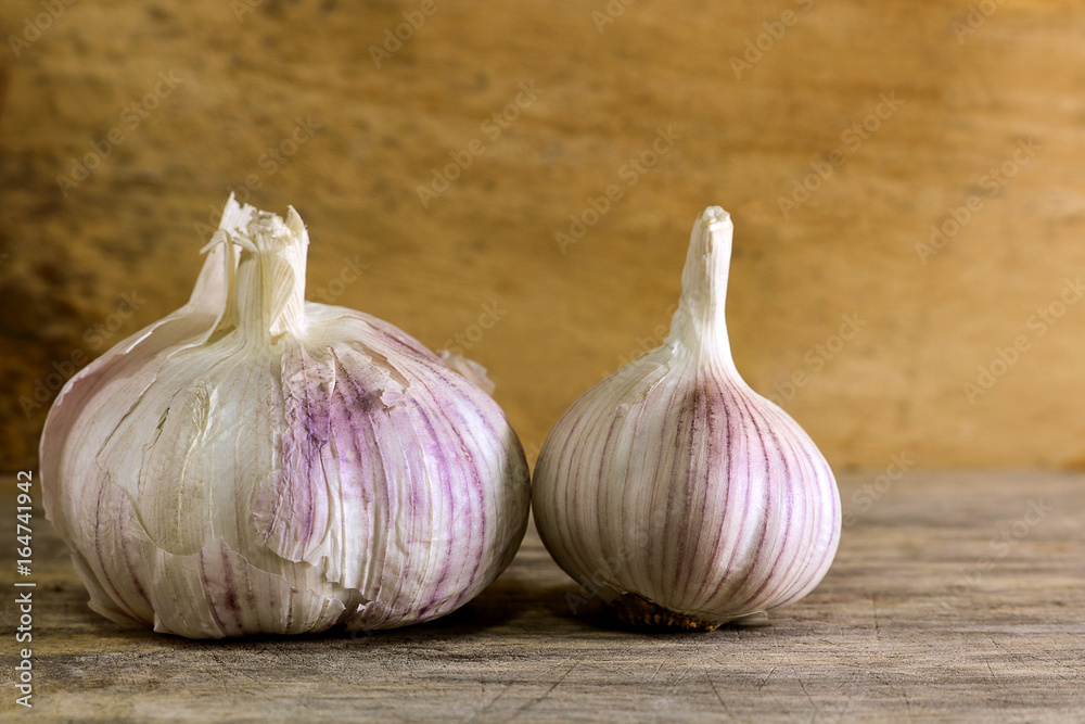Obraz premium Garlic clove and garlic bulb on wooden background