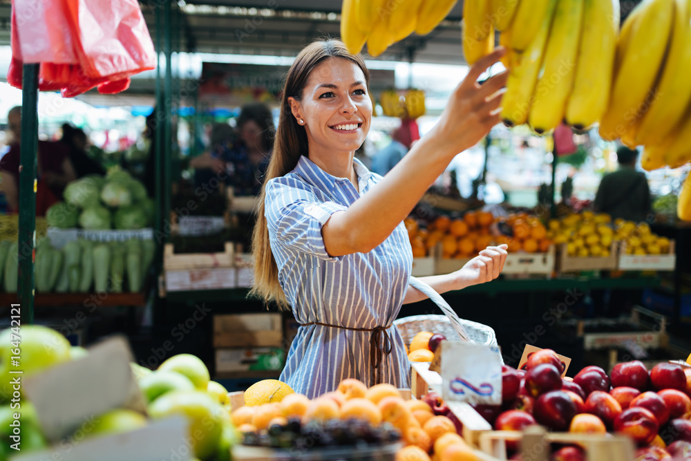 Obraz premium Picture of woman at marketplace buying fruits