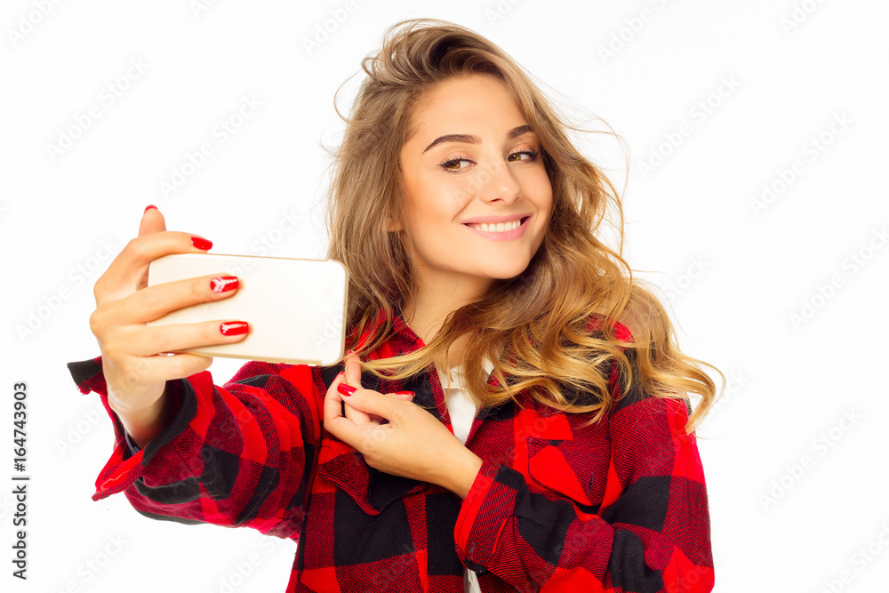 Portrait of a beautiful young woman making selfie on smart phone. Happy young woman photographing herself. Portrait of a beautiful young woman making selfie on smart phone. Happy young woman photographing herself.