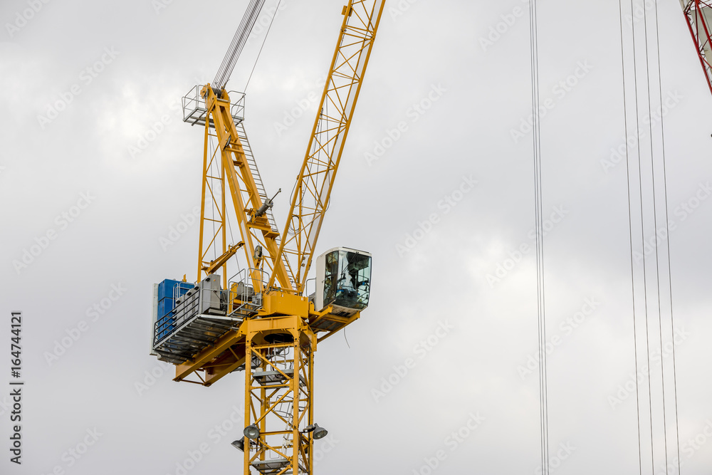 Building construction tower crane yellow cabin with operator Building construction tower crane yellow cabin with operator