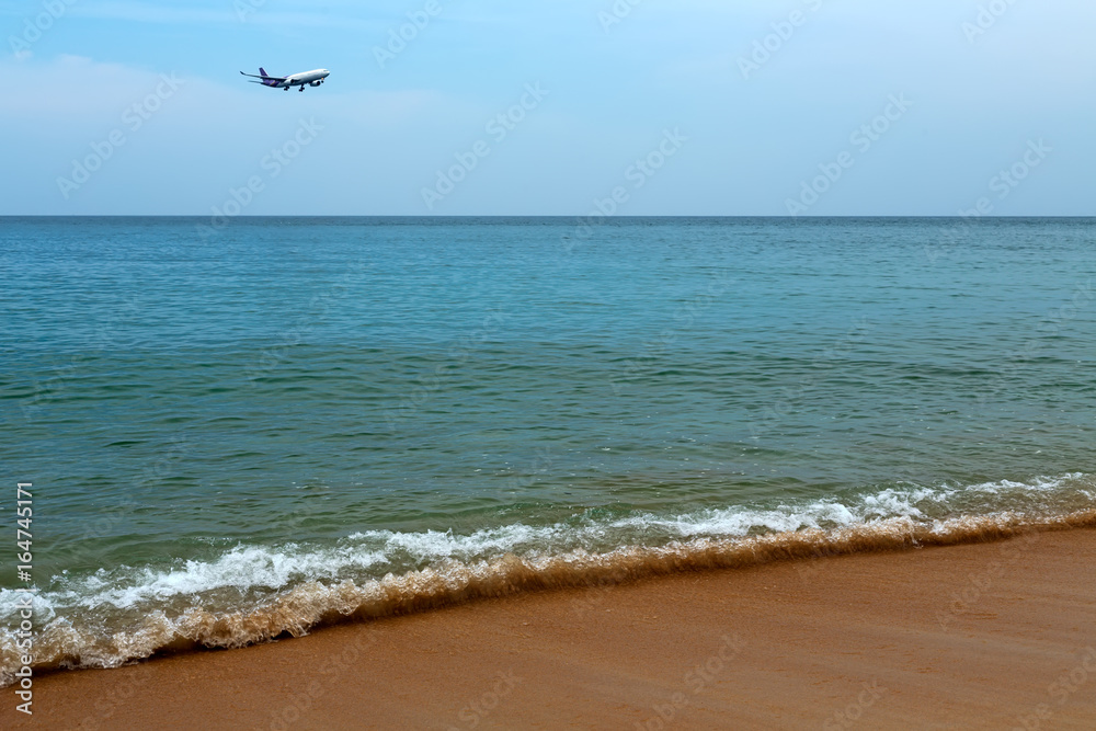 Plane comes in to land on a tropical beach
