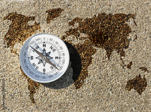 Compass and world map on small gravel stone, Find the right way for our earth concept