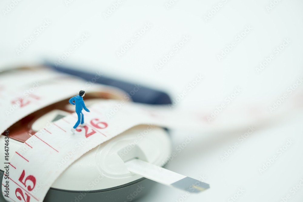 Fototapeta premium Close up of runner miniature figure running on measure tape binding on Glucose meter with blood sugar test strip and lancet - use for Medicine, diabetes, glycemia, sport, health care andconcept.