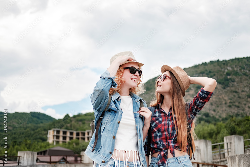 Two girls in hats traveling through ruins