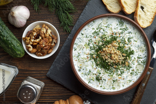 Homemade chilled tarator with ingredients on wooden rustic background.