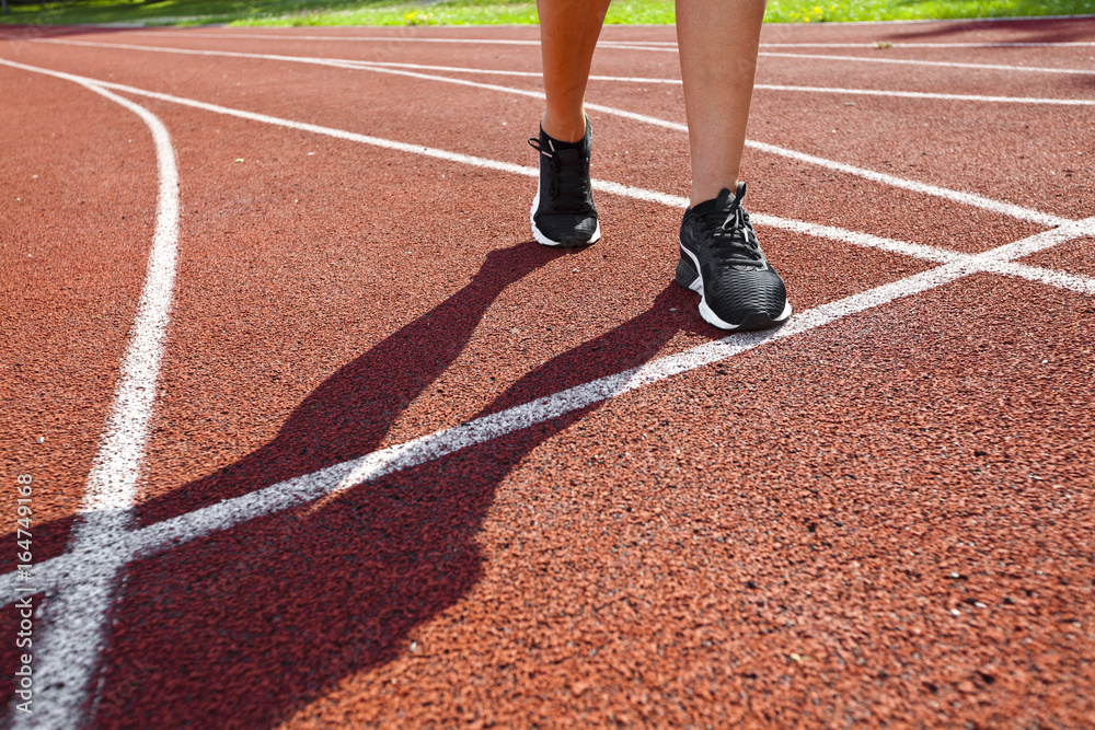 Athlete on starting line waiting for the start in running track Athlete on starting line waiting for the start in running track