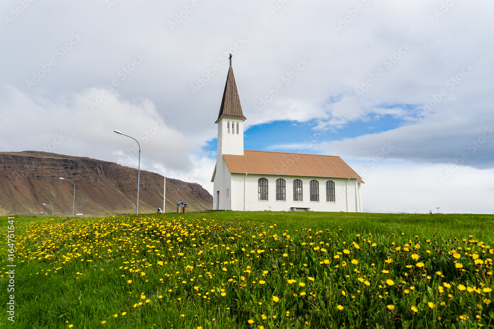 Reykholakirkja, surrounded by flowers in Reykholar, Iceland