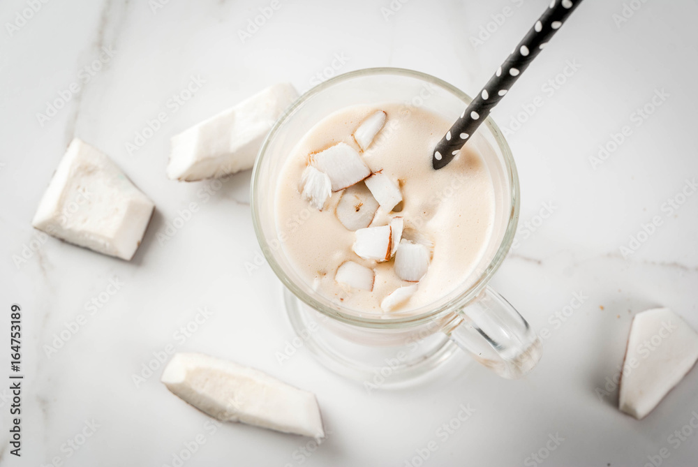Vegan food. Refreshing summer cocktails. beverages. Coconut latte smoothie - with coffee, coconut cream (milk), pieces of coconut. On a white marble kitchen table. Copy space Vegan food. Refreshing summer cocktails. beverages. Coconut latte smoothie - with coffee, coconut cream (milk), pieces of coconut. On a white marble kitchen table. Copy space
