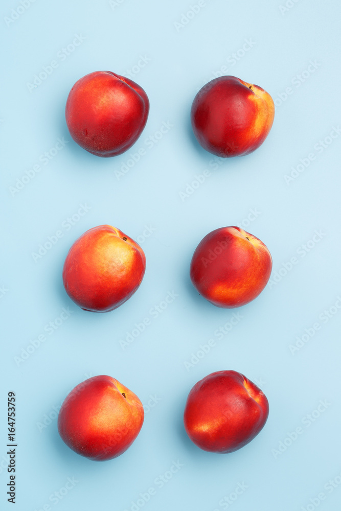 A few ripe nectarines on a blue background A few ripe nectarines on a blue background